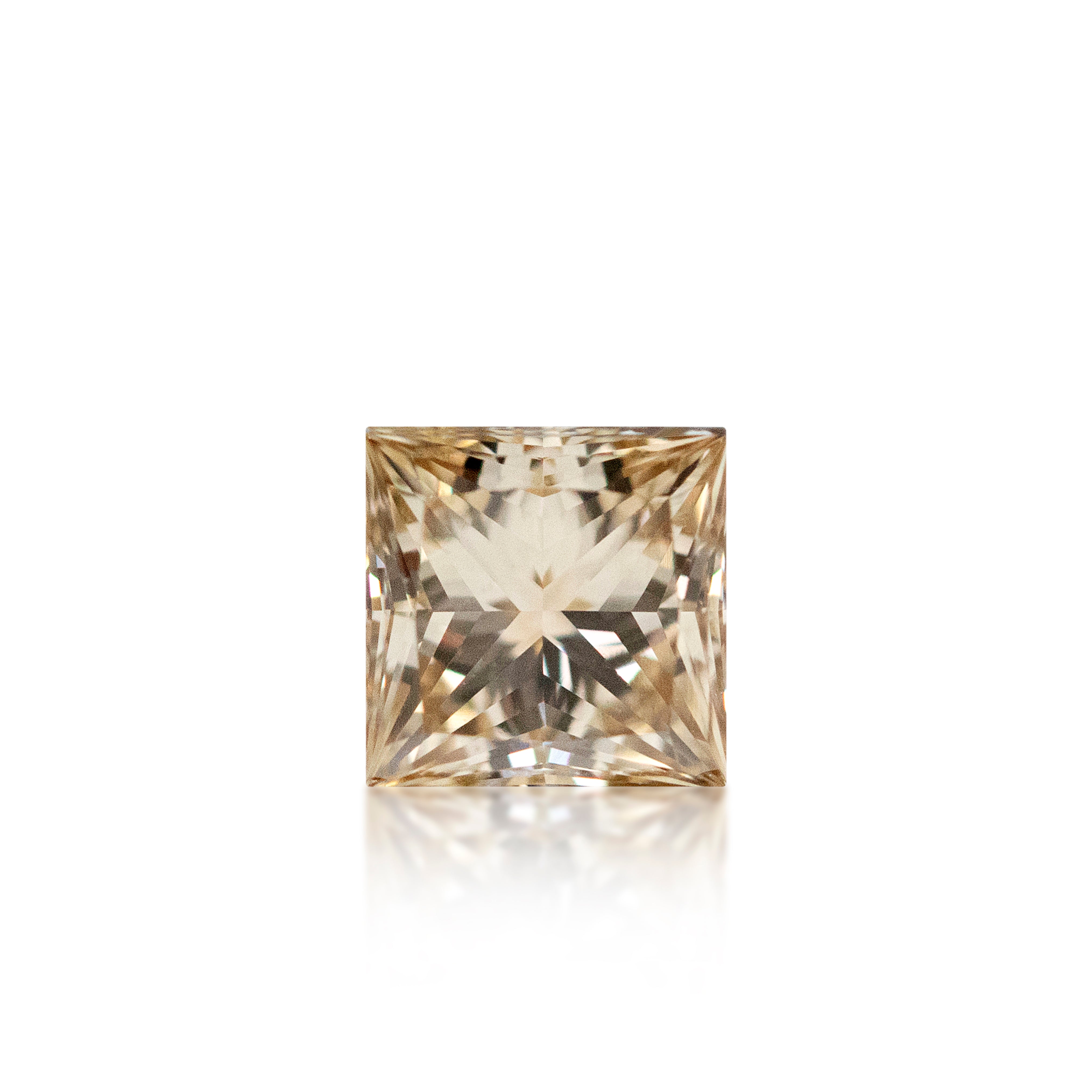 A single princess-cut radiant diamond with a light peachy-brown tint, centered on a clean white background with a soft reflection below.