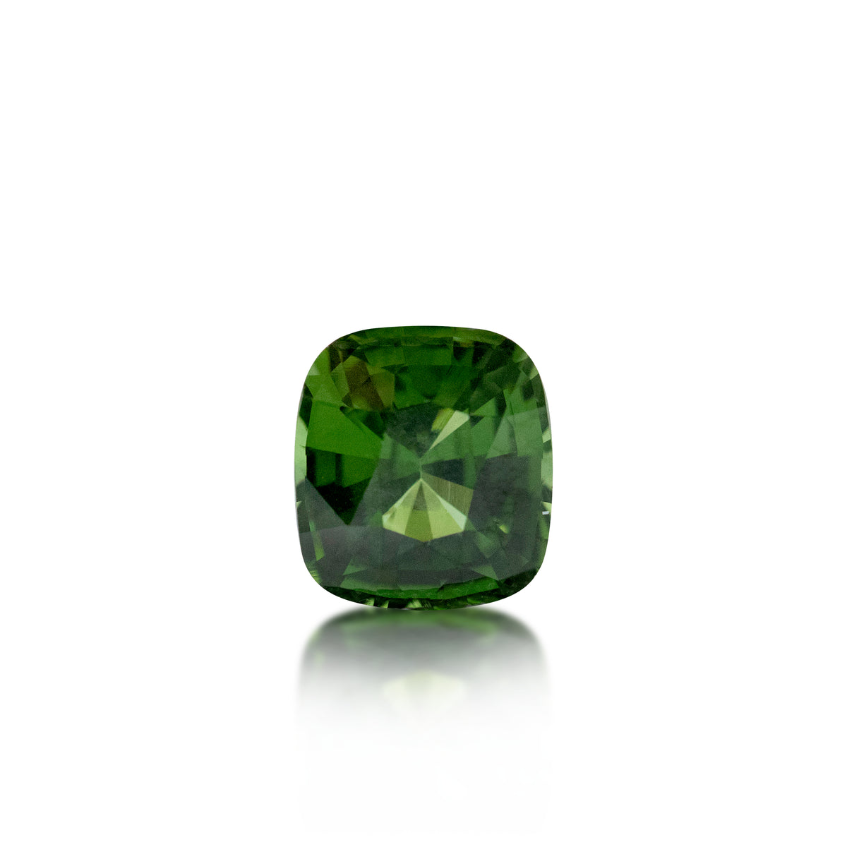 A cushion-cut green gemstone with a faceted cushion shape, displayed on a clean white background with a soft reflection below.