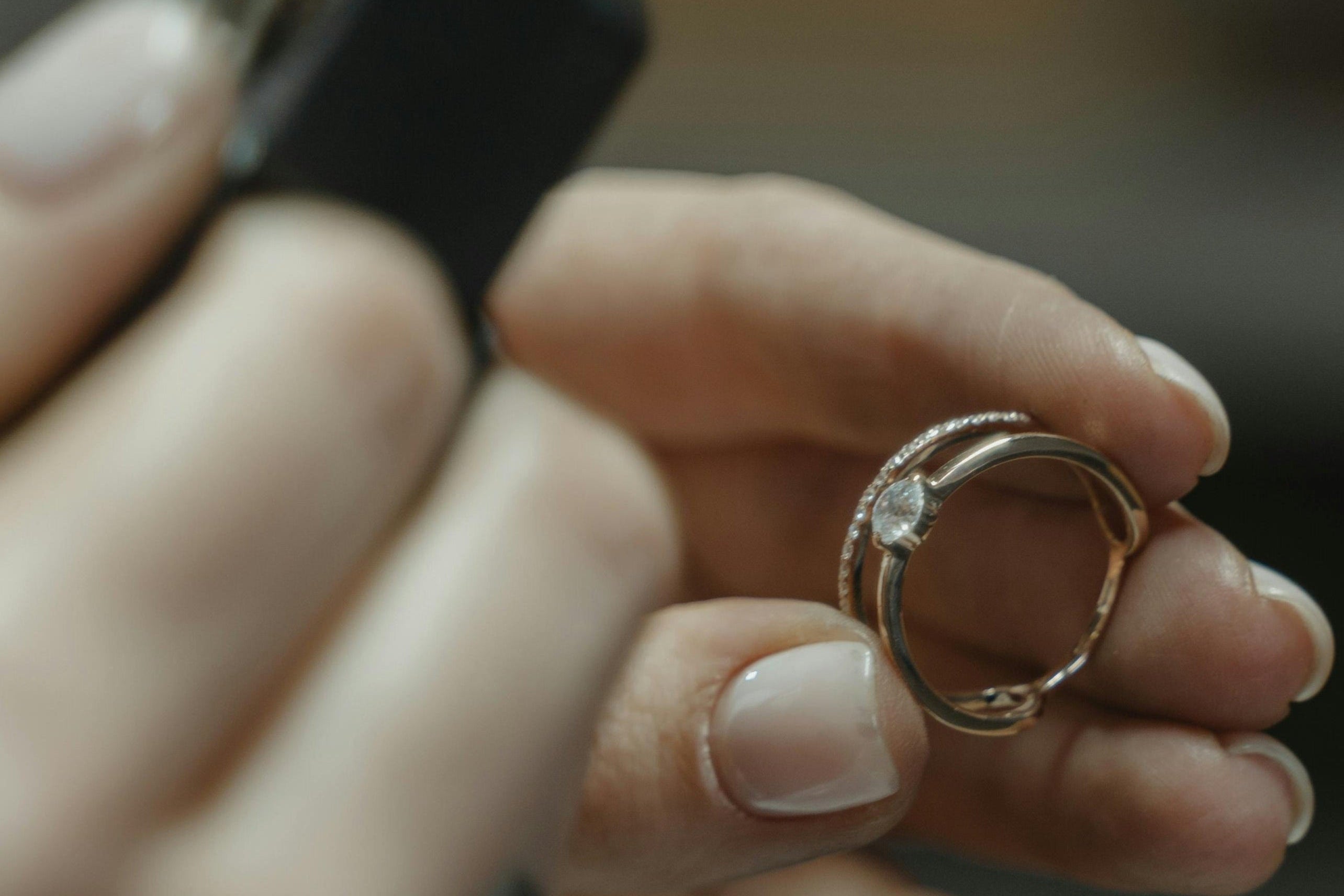 Close-up of hands holding a ring against a blurred background